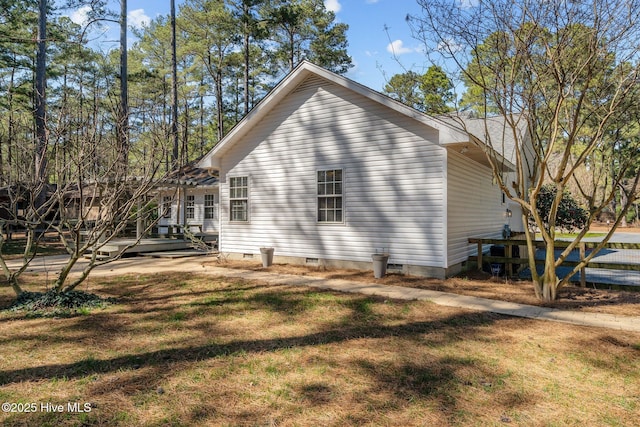 view of property exterior featuring crawl space, a lawn, and a wooden deck