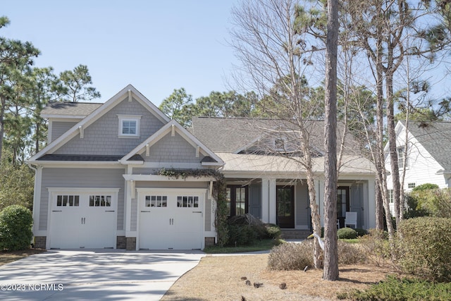 craftsman inspired home featuring a garage, stone siding, and driveway