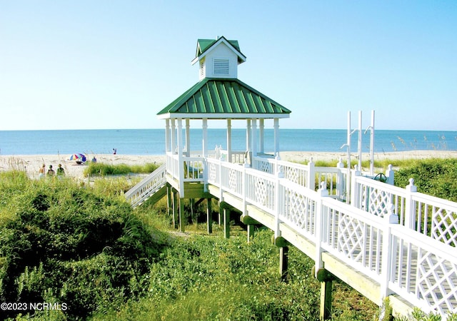 view of property's community with a water view and a view of the beach