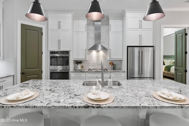 2900 Legends Dr, Southport, NC 28461 - kitchen with stainless steel appliances, wall chimney range hood, a sink, and white cabinetry
