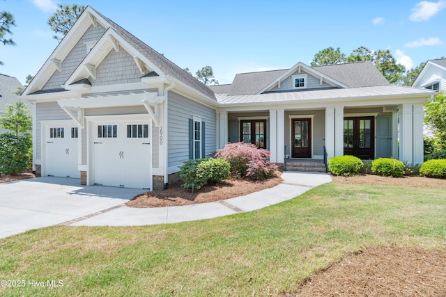 2900 Legends Dr, Southport, NC 28461 - view of front of home with an attached garage, concrete driveway, a front lawn, a porch, and metal roof