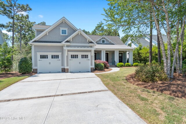 2900 Legends Dr, Southport, NC 28461 - craftsman inspired home featuring driveway, covered porch, a front yard, and a shingled roof