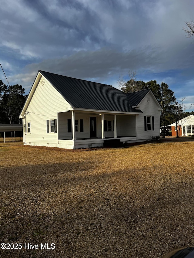 view of front of house with covered porch, metal roof, and crawl space