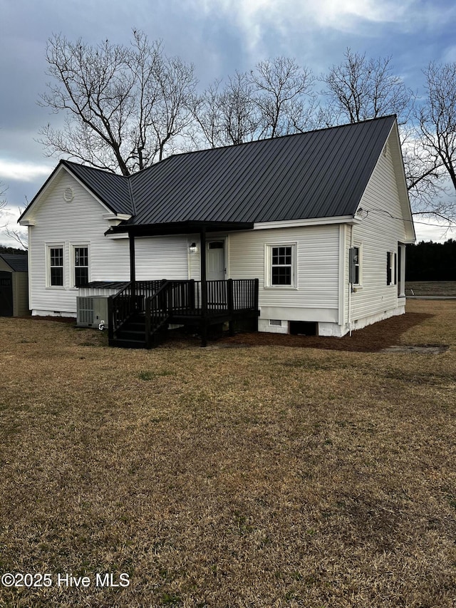 back of house featuring central air condition unit, a lawn, crawl space, metal roof, and a wooden deck