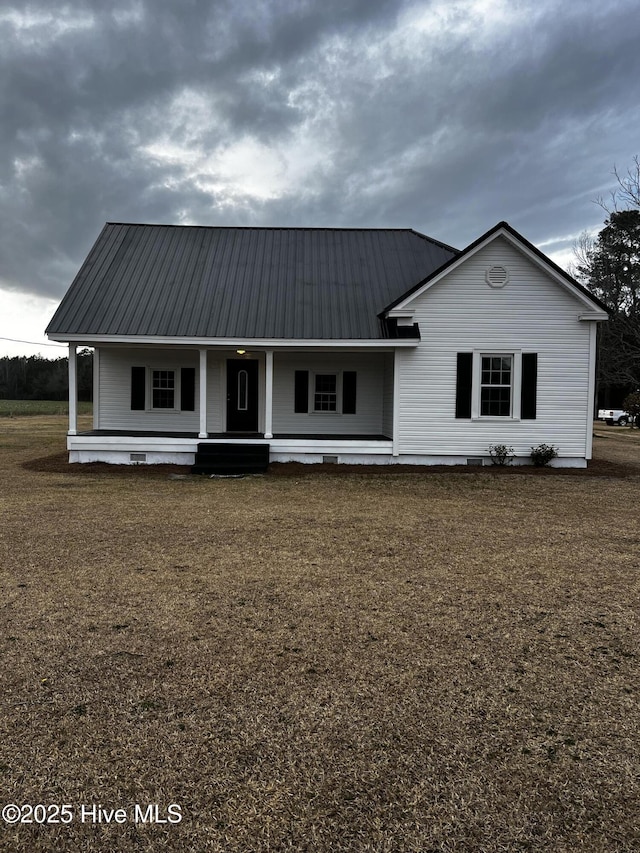 view of front facade featuring a porch, crawl space, and metal roof