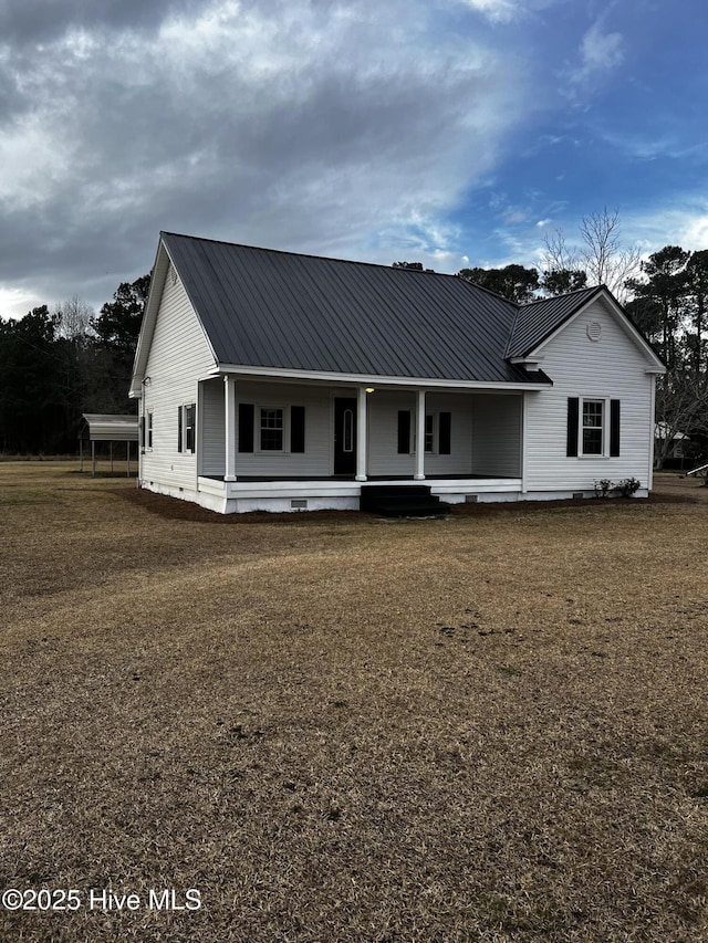 view of front of house featuring metal roof, a porch, crawl space, and a front lawn