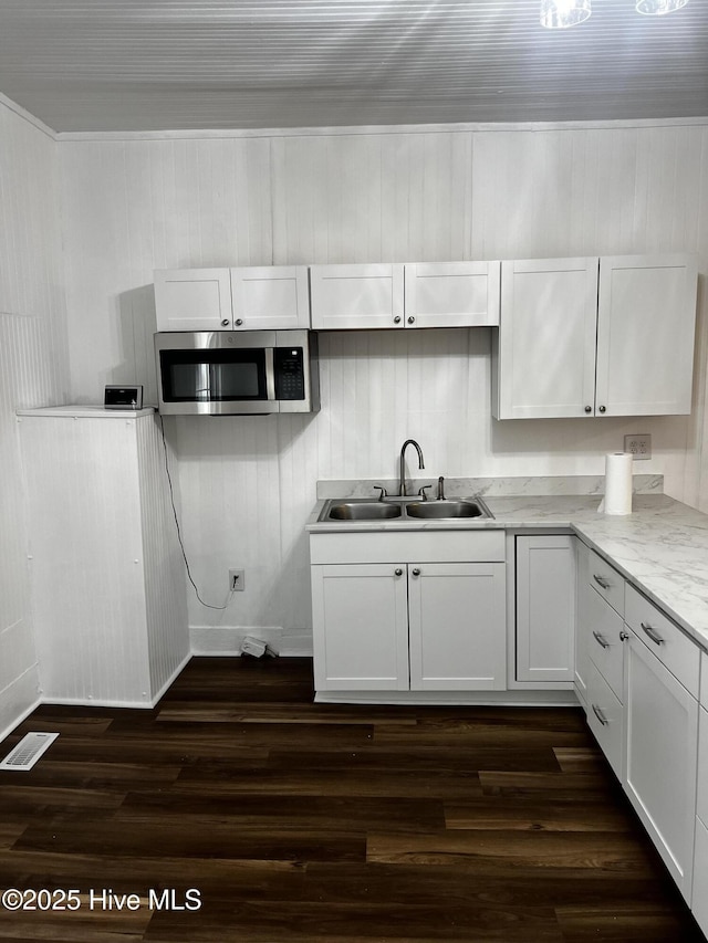 kitchen featuring visible vents, stainless steel microwave, dark wood-style flooring, and a sink