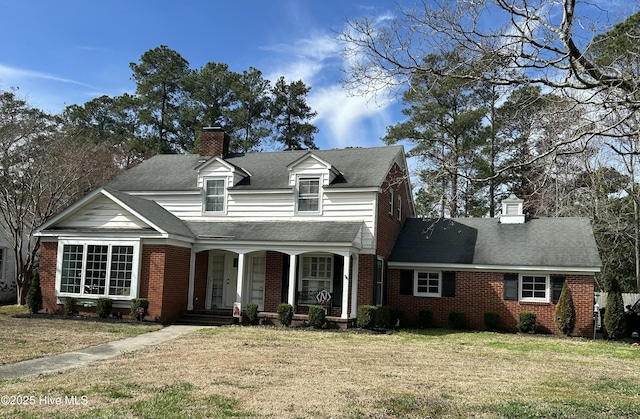 view of front of property featuring brick siding, a chimney, and a front lawn