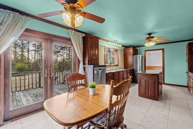 dining space featuring light tile patterned floors, baseboards, crown molding, and a ceiling fan