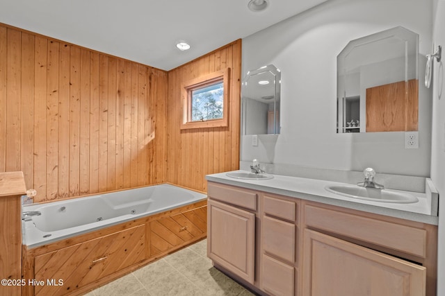 full bath featuring double vanity, a whirlpool tub, and a sink