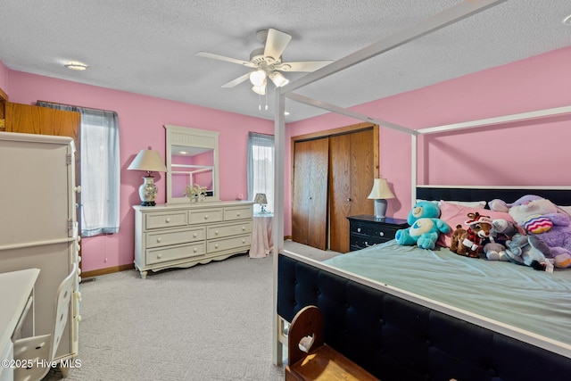 carpeted bedroom featuring a closet, baseboards, a textured ceiling, and ceiling fan