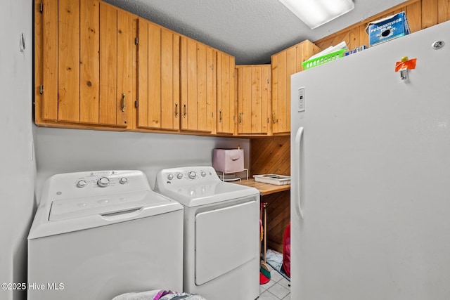 laundry area with a textured ceiling, cabinet space, and washing machine and clothes dryer