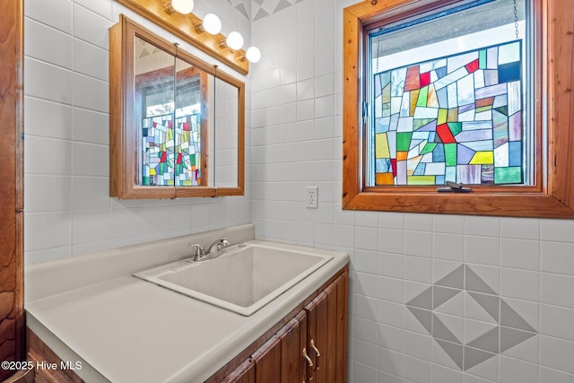 bathroom featuring vanity and tile walls