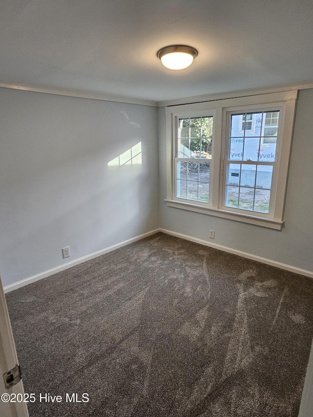 unfurnished room featuring dark carpet and baseboards