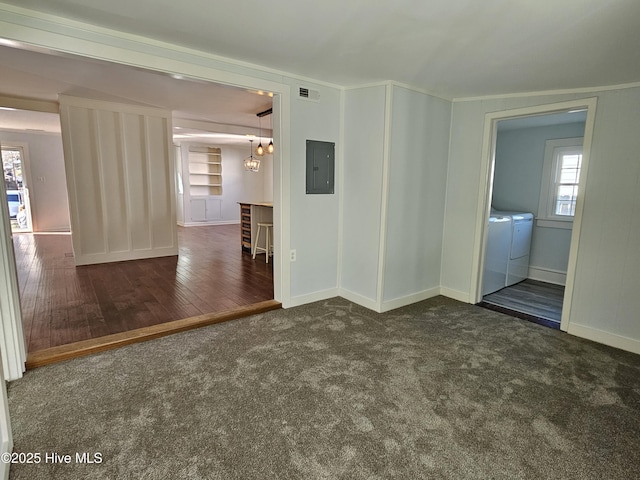 unfurnished room featuring carpet floors, visible vents, wood finished floors, electric panel, and independent washer and dryer