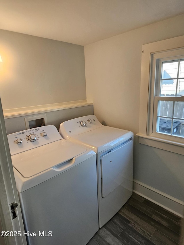 clothes washing area featuring laundry area, dark wood-type flooring, washing machine and dryer, and baseboards