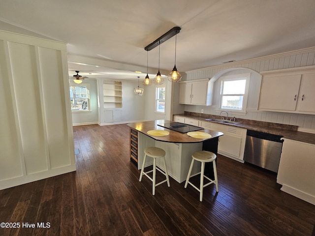 kitchen featuring dark wood-style flooring, dark countertops, white cabinetry, a sink, and dishwasher