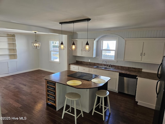 kitchen featuring dark wood-type flooring, dark countertops, white cabinetry, and dishwasher