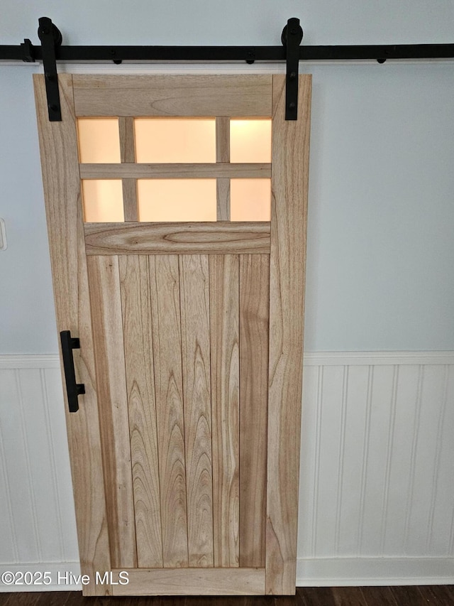 room details featuring a wainscoted wall and a barn door