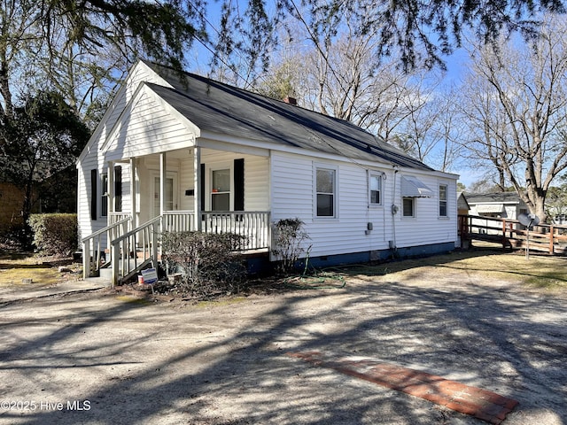 view of front facade with crawl space, covered porch, and fence