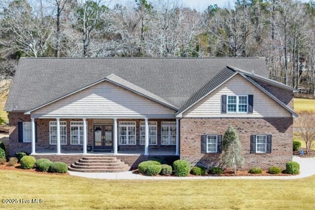 906 Taberna Cir, New Bern, NC 28562 - view of front of house with french doors, brick siding, covered porch, and a front yard