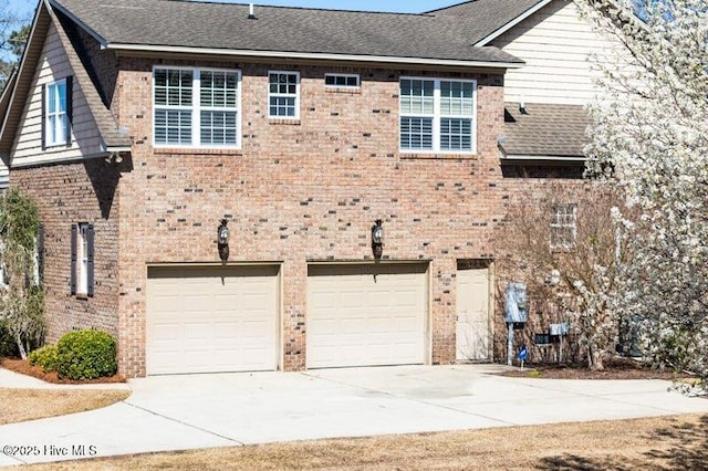 906 Taberna Cir, New Bern, NC 28562 - back of property featuring brick siding, driveway, a shingled roof, and an attached garage