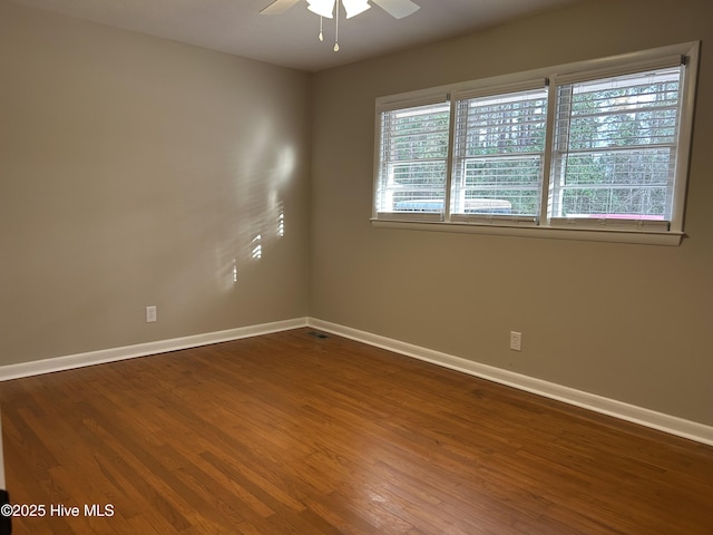 spare room featuring a ceiling fan, baseboards, and wood finished floors