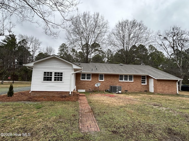 rear view of house featuring a yard, brick siding, crawl space, and a shingled roof