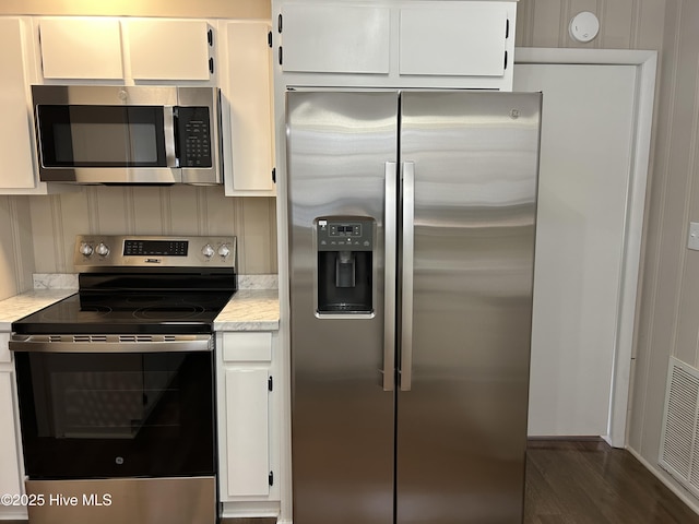 kitchen featuring visible vents, white cabinets, dark wood-style floors, appliances with stainless steel finishes, and light countertops