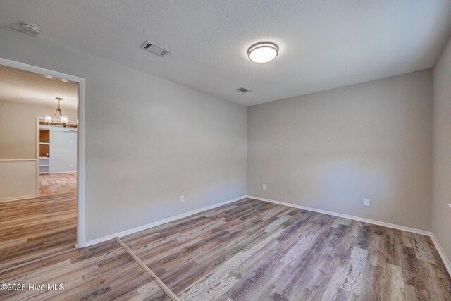 137 El Ogden Dr, Wilmington, NC 28411 - unfurnished room featuring a chandelier, visible vents, baseboards, and wood finished floors