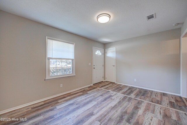 137 El Ogden Dr, Wilmington, NC 28411 - foyer with baseboards, a textured ceiling, visible vents, and wood finished floors