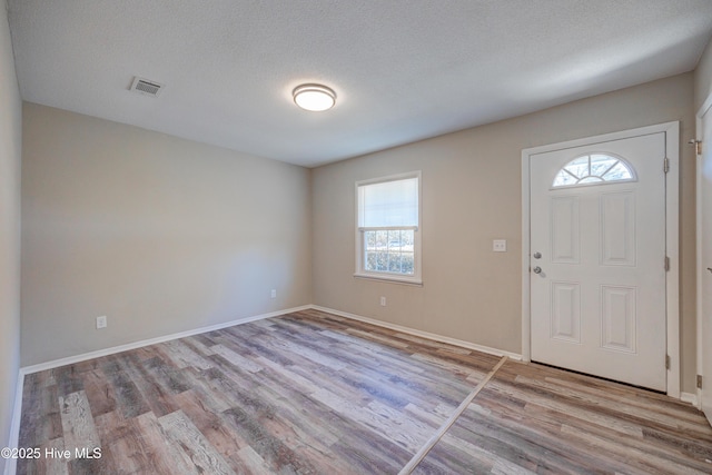 137 El Ogden Dr, Wilmington, NC 28411 - entryway featuring a textured ceiling, plenty of natural light, wood finished floors, and visible vents