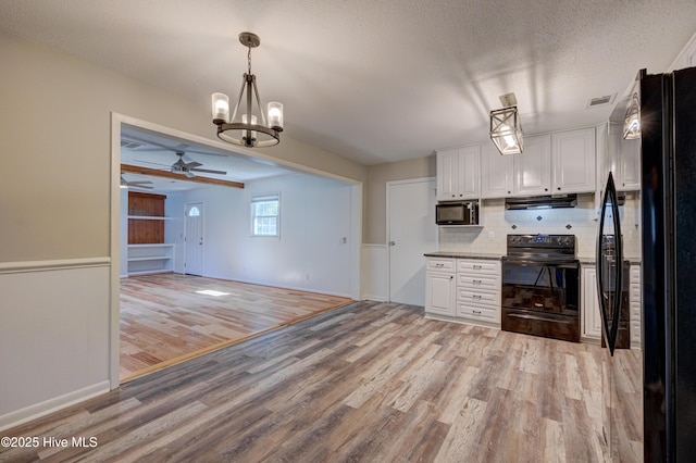 137 El Ogden Dr, Wilmington, NC 28411 - kitchen featuring light wood-type flooring, white cabinets, under cabinet range hood, and black appliances