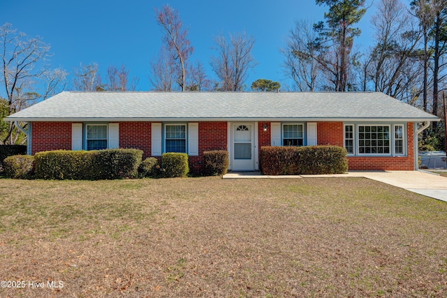 single story home featuring a front yard, brick siding, and roof with shingles