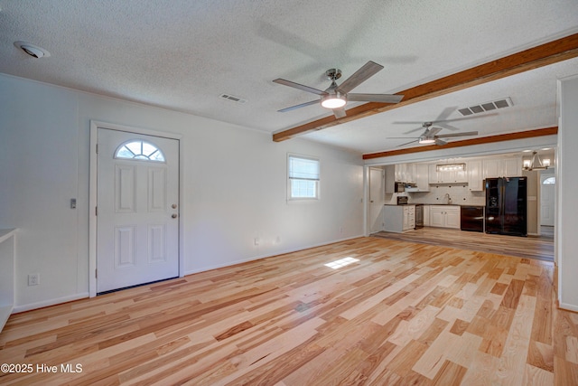 137 El Ogden Dr, Wilmington, NC 28411 - unfurnished living room with a textured ceiling, light wood finished floors, beamed ceiling, and visible vents