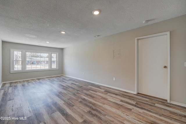 137 El Ogden Dr, Wilmington, NC 28411 - unfurnished room featuring a textured ceiling, wood finished floors, and baseboards