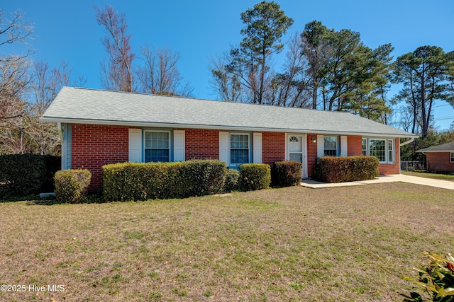 ranch-style house with a front lawn, a shingled roof, and brick siding