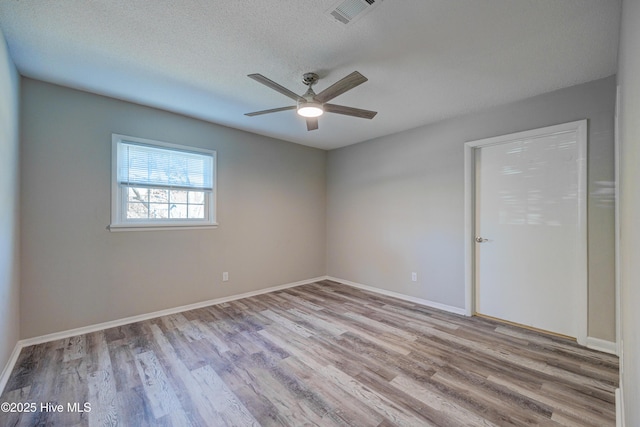 137 El Ogden Dr, Wilmington, NC 28411 - spare room featuring baseboards, visible vents, ceiling fan, wood finished floors, and a textured ceiling
