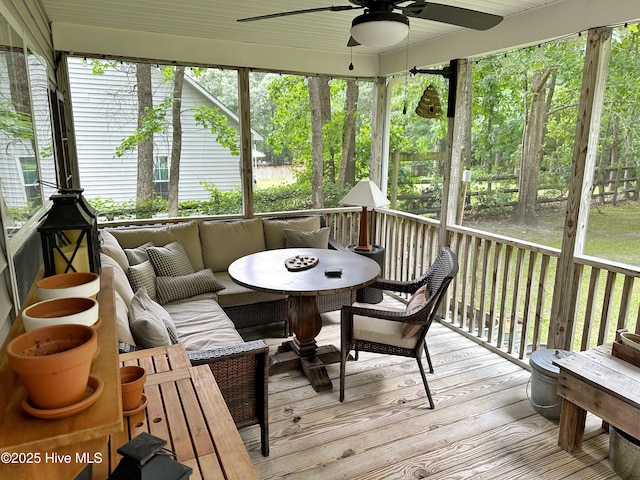 sunroom / solarium featuring a ceiling fan