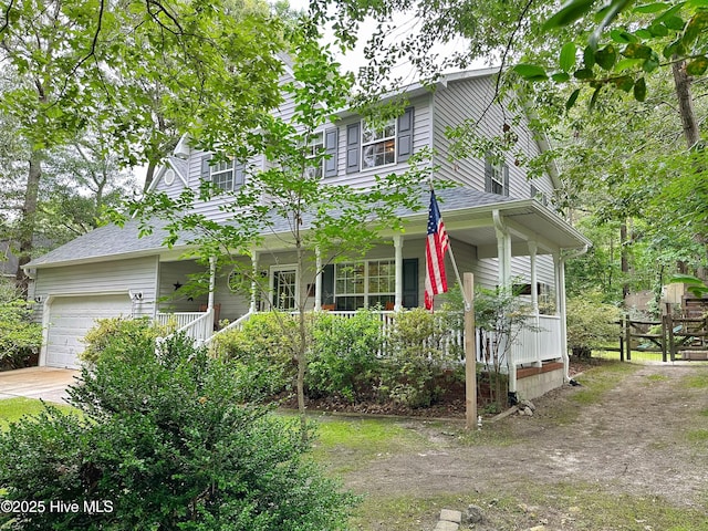 view of front facade with a garage, covered porch, driveway, and a shingled roof