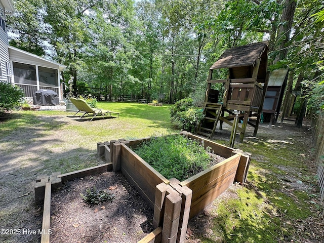 view of yard featuring a sunroom and a garden