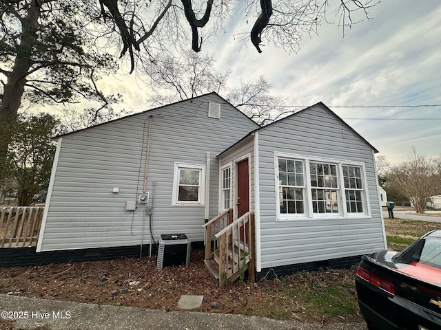 back of house featuring entry steps, fence, and central air condition unit
