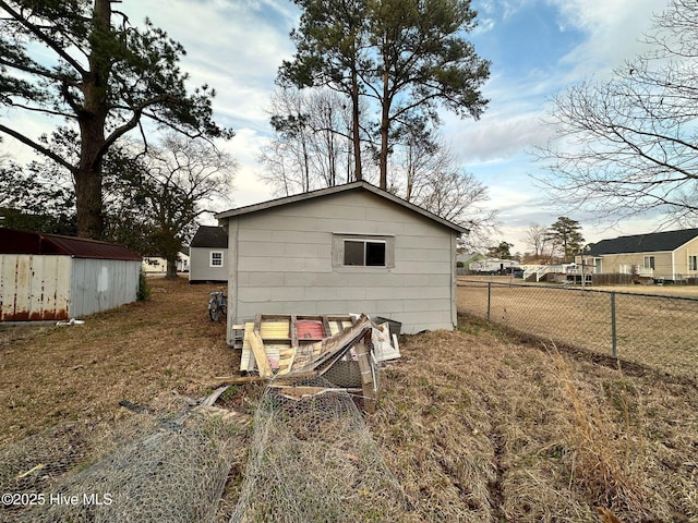rear view of property with fence and an outdoor structure