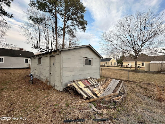 view of outdoor structure featuring fence and an outdoor structure