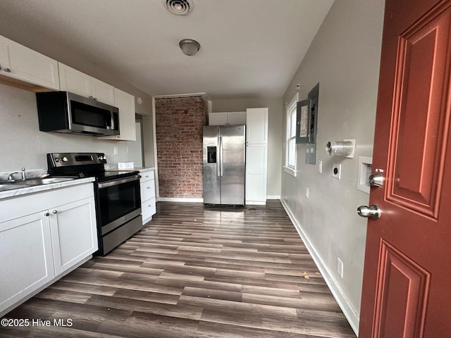 kitchen with dark wood-style floors, stainless steel appliances, visible vents, and white cabinetry