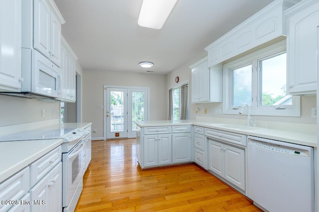 917 Hearthside Ct, New Bern, NC 28560 - kitchen with white appliances, a sink, white cabinetry, light countertops, and light wood-style flooring