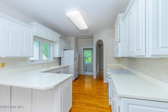 917 Hearthside Ct, New Bern, NC 28560 - kitchen featuring white appliances, a sink, a peninsula, white cabinets, and light wood finished floors