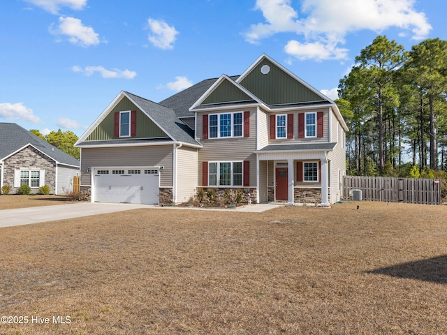 craftsman-style house featuring driveway, stone siding, an attached garage, and fence