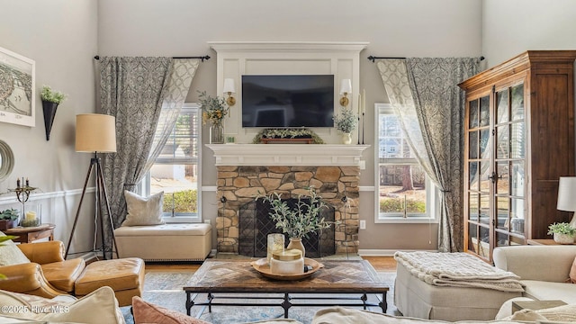 living area featuring a fireplace, wood finished floors, and baseboards