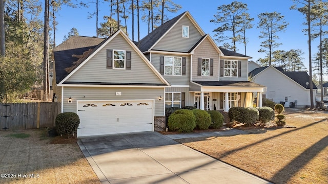 view of front of property featuring covered porch, brick siding, driveway, and fence